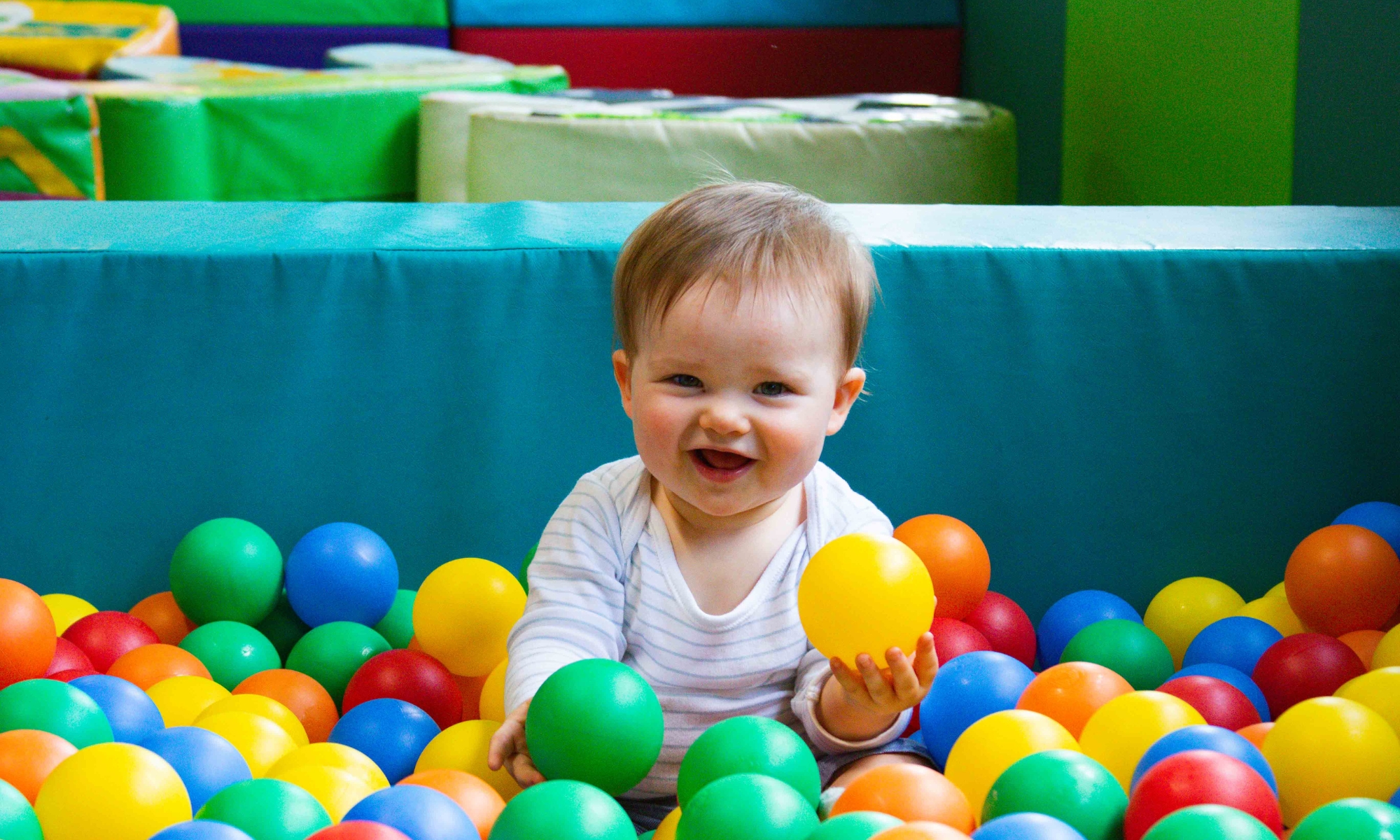 Infant playing in the ball pit at the Play Barn Café at Wroxham Barns.
